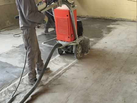 Grind concrete to prepare for the application of a specified coating.